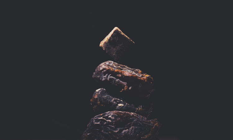 A CAFF energy bite balanced on a stack of Medjool dates